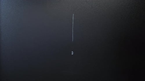 Écrire un point d'exclamation à la craie sur un tableau noir.