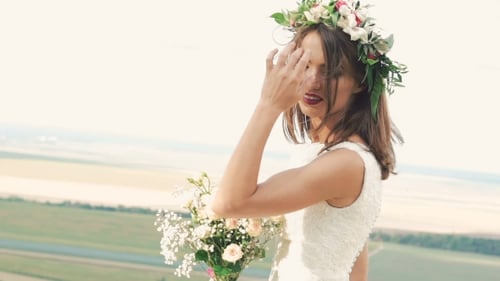 Bride Holding Flowers in Rural Field
