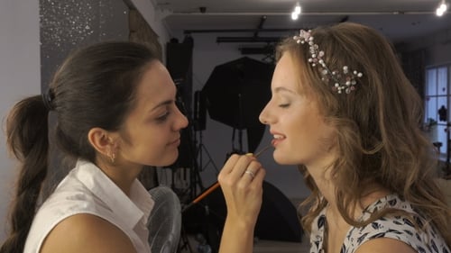 Makeup Artist Applying Lipstick in Studio