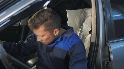Professioneller Automechaniker, der im modernen Autoreparaturservice arbeitet und den Motor überprüft