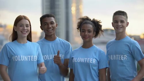 Happy Volunteers Giving Thumbs Up in Urban Setting
