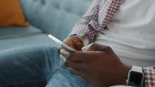 Young Adult Using Phone Sitting on a Couch