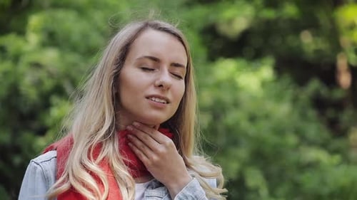 Woman Touches Neck, Possible Sore Throat Outside