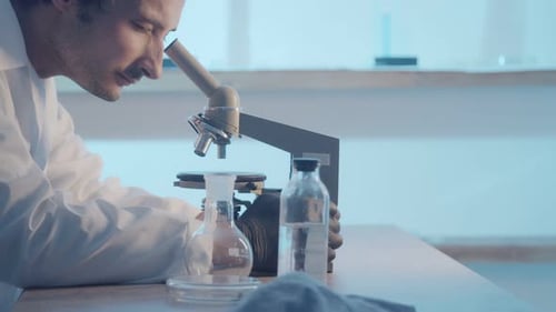 Scientist Using Microscope in Medical Laboratory