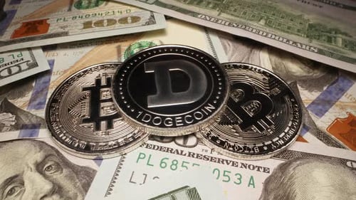 Crypto Dogecoin placé sur du Bitcoin argenté empilé sur des billets de 100 dollars