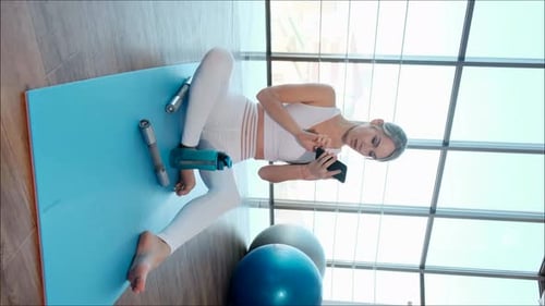 Woman Using Smartphone After Home Workout Session