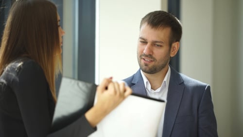 Businesswoman And Businessman Standing In Office And Discussing Business Ideas