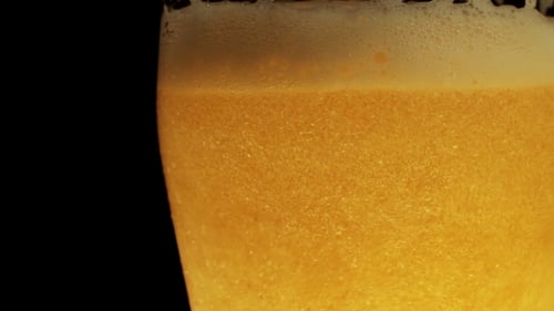 Beer Pouring Into Glass Creating Frothy Texture