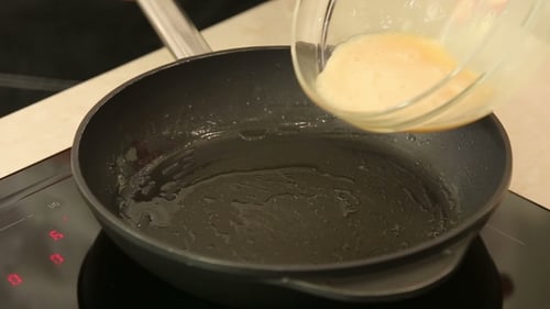 Pouring Eggs into Hot Frying Pan for Cooking