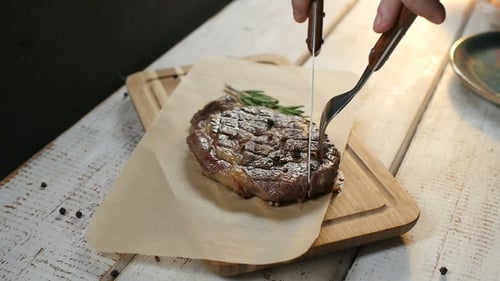 Juicy Steak Being Cut with Knife and Fork