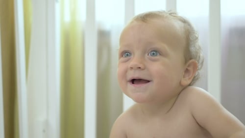 Baby Boy Smiling in White Crib