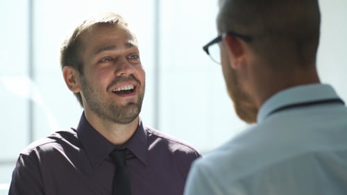 Two Men Talking In The Lobby Of The Office