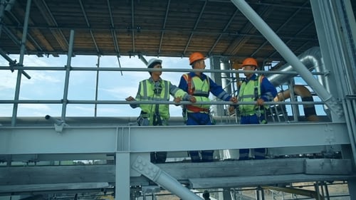 Workers In Production Plant As Team Discussing, Industrial Scene In Background