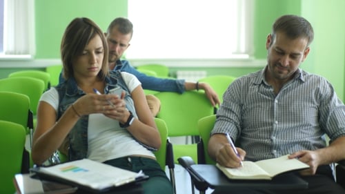 Students in Classroom Taking Notes and Using Phone