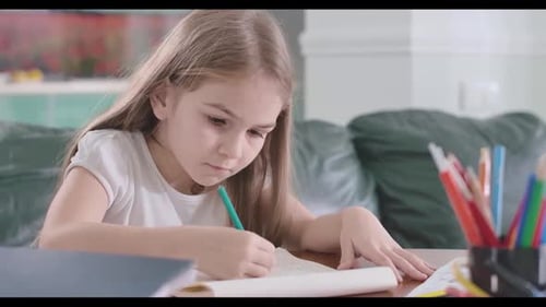 Close-up of Focused Caucasian Girl Doing Math at Home, Clever Schoolgirl Doing Homework at the Table