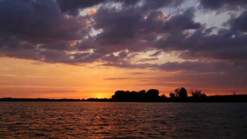 Colour Sunset Over The River With Sun And Orange Clouds