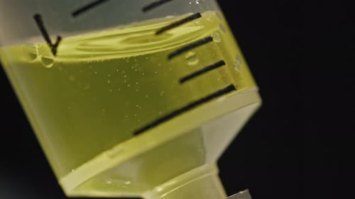 Macro of Yellow Liquid Medicine Fills in Plastic Syringe Slowly in Laboratory
