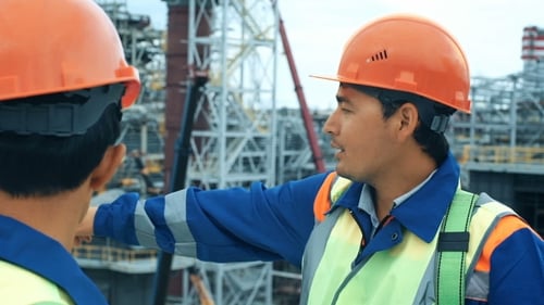Construction Workers Discussing Progress at Industrial Site