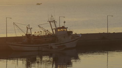 Fishing Boat Docked in Harbor at Sunset