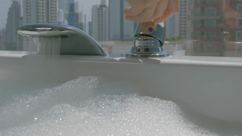 Modern Chrome Faucet Filling Bubble Bath in City Apartment