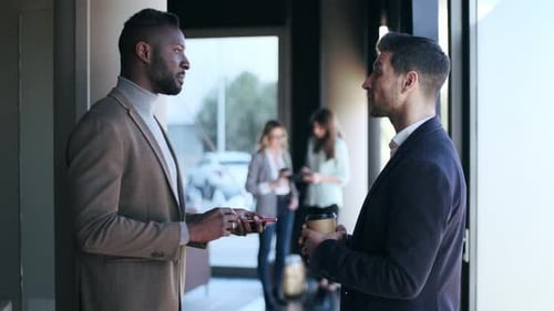 Two businessmen discussing in front of office building