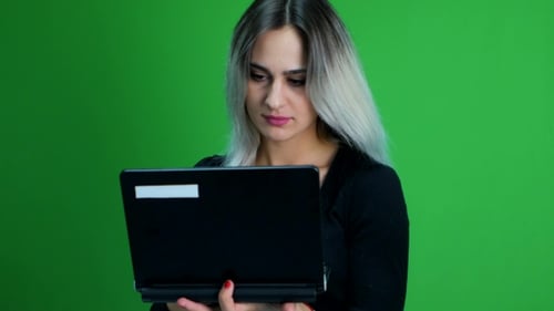 Young Attractive Woman Works On Notebook And Smiles - Green Screen Studio