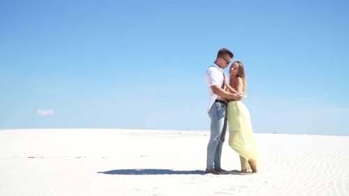 Loving Couple Embracing In The Desert In The Wind