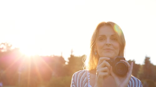 Woman Photographing with Camera in Sunny Field