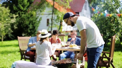 Friends Having Barbecue Party At Summer Garden