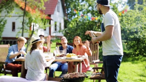 Friends Having Barbecue Party At Summer Garden