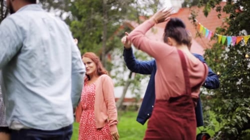Amigos felizes dançando na festa de verão no jardim