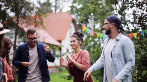 Amigos felizes dançando na festa de verão no jardim
