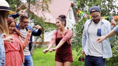 Happy Friends Dancing At Summer Party In Garden