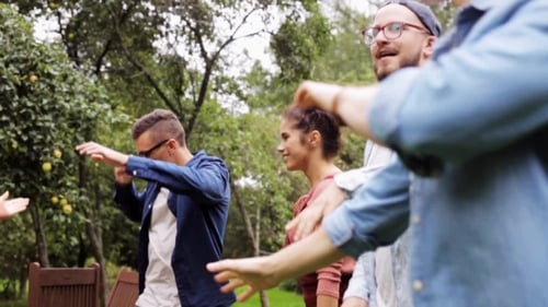 Happy Friends Dancing At Summer Party In Garden