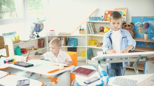 Boys Painting and Sketching in a Sunlit Classroom