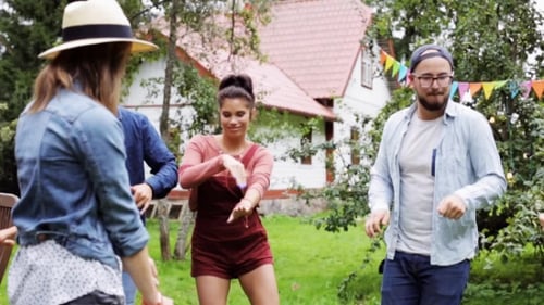 Amigos felizes dançando na festa de verão no jardim
