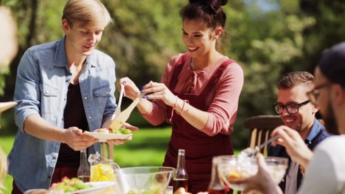 Happy Friends Having Dinner At Summer Garden Party