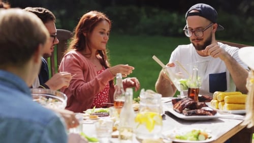Happy Friends Having Dinner At Summer Garden Party