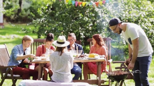 Friends Having Barbecue Party At Summer Garden