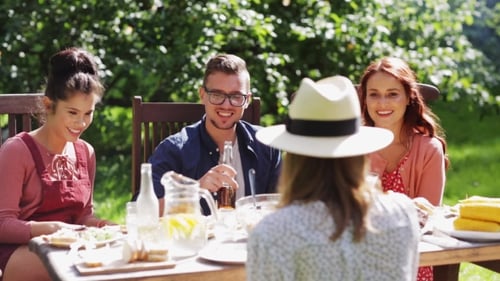 Happy Friends Having Dinner At Summer Garden Party