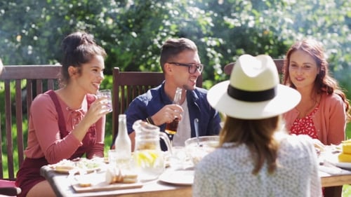 Happy Friends Having Dinner At Summer Garden Party