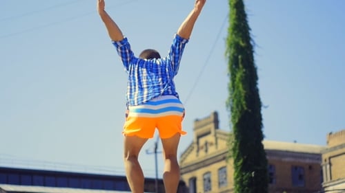 Guy Athlet macht am Strand einen Backflip mit einer Doppelpirouette