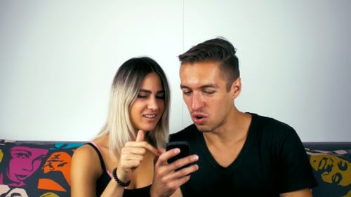 Couple Looking at Phone Laughing and Smiling