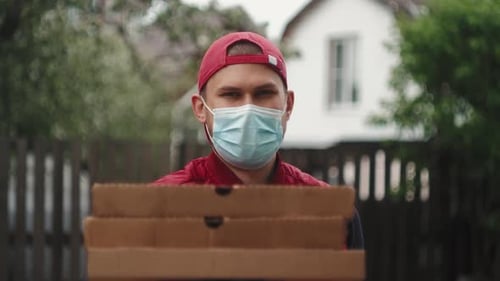 Young Adult Delivering Pizza Wearing a Mask
