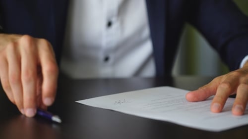 Empresário está assinando um contrato, detalhes do contrato comercial