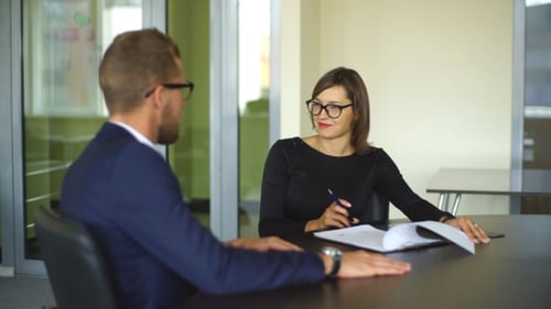 Business Meeting In Office Two Business People Discussing Contract