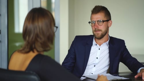 Young Businessman Discussing The Terms Of The Contract With Businesswoman In Office