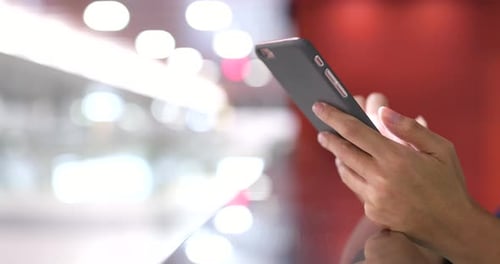 Hands Hold Cellphone and Touch Screen Indoors