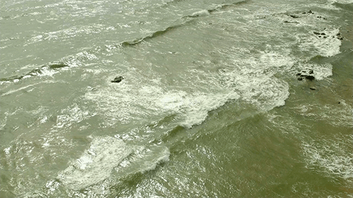 Aerial View of Waves Crashing on Beach Shoreline
