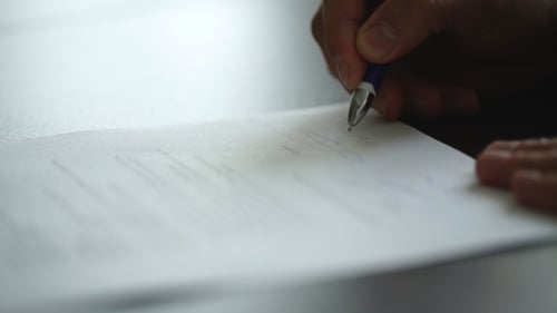 Hand Signing Document with Blue Pen, Close Up